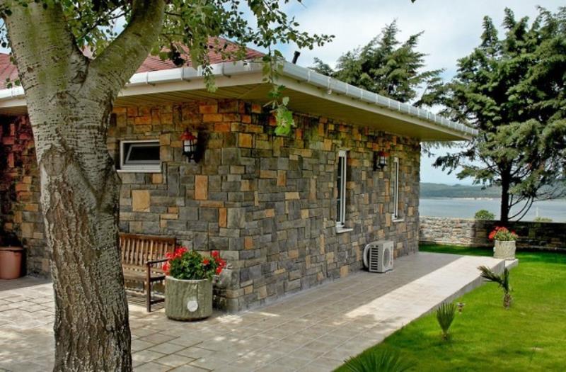 Villa dış cephe doğal dokulu kültür taşı kaplama ve bahçe duvarı uygulama örneği.