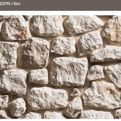 Mekanı aydınlatan inci beyazı, doğal dokulu tekli kaplama taşı.